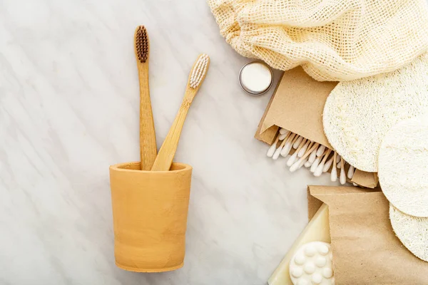 Bamboo toothbrushes in hand made clay glass, soap Cotton Swabs Wooden Sticks,loofah washcloths on white marble background. Natural bath product. Eco friendly, Zero waste, Plastic free Dental care — Stock Photo, Image