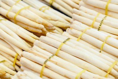 Çiftçi pazarında satılık taze çiğ beyaz organik kuşkonmaz sebzeleri. Vejetaryen yiyecekler ve sağlıklı beslenme. Arkaplan olarak beyaz kuşkonmaz resmi koyun. Markette çiğ beyaz kuşkonmaz.