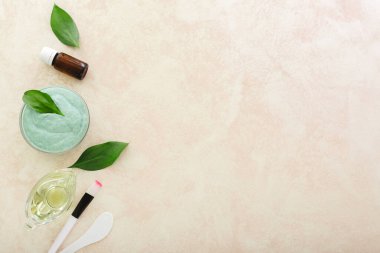 Cosmetology set for cooking, applying face mask. Avocado face mask, spatula, brush, oil,essential oil on light pink background with copy space for text.Skin care, nutritious rejuvenating cosmetic mask