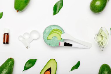 Yemek pişirme ve yüz maskesi takmak için kozmetoloji hazır. Avokadolar, yapraklar, avokado maskesi, spatula, fırça, ölçüm kaşıkları, beyaz arka planda gerekli yağ. Cilt bakımı, besleyici gençleştirici kozmetik