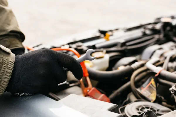 Car mechanic engineer using a wrench in process of fixing a car. Male hands of car mechanic with a wrench working in garage. Man in gloves working in car repair service station. — 스톡 사진