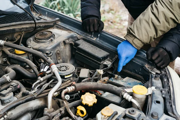 Two Car mechanic engineers checking, fixing the car, making maintenance comprehensive auto check. Auto mechanic in blue gloves detected breakdown and indicates a malfunction. Car repair service — 스톡 사진