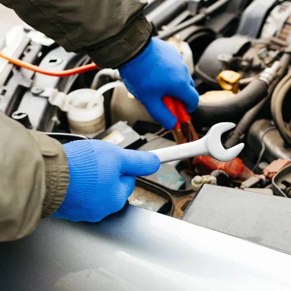 Car mechanic engineer using a wrench in process of fixing a car. Male hands of car mechanic with a wrench working in garage. Man in gloves working in car repair service station. — 스톡 사진