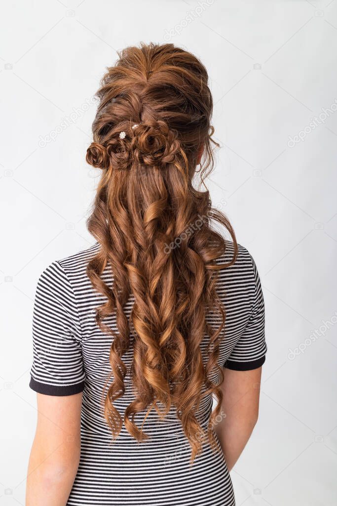 Wave curls hairstyle. Hairstyle on red brown hair woman with long hair on a white background. Professional hairdressing services.Hair styling, making braid with hairpin