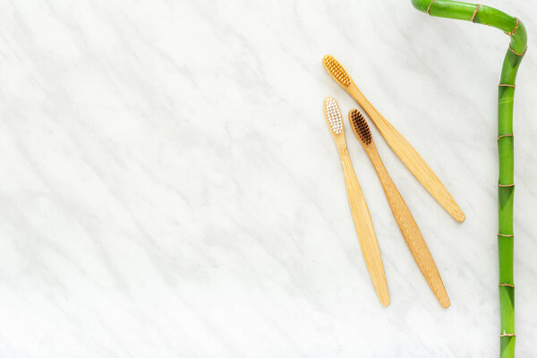 Bamboo toothbrushes on wooden background. Flat lay with copy space. Natural bath products. Biodegradable natural bamboo toothbrush. Eco friendly, Zero waste, Dental care Plastic free concept.