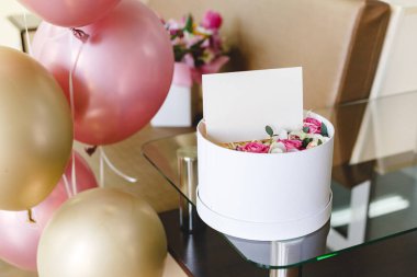 İçinde boş kart olan çiçek kutusu, güllerin çiçek kompozisyonu. Anneler günü için hediye buketi, kadınlar günü, doğum günü ve tebrik kartı içinde tasarımın için boş yer olan hediye kartı, logo. Şenlik balonları