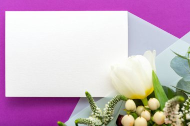 Çiçekler düğün davetiyesini taklit eder. Tebrik kartı, beyaz çiçek demetinde laleler, mor arka planda okaliptüsler. Boş kart, mesaj için yer, çerçeve modeli, hediye kartı. Bahar şenliği çiçekleri