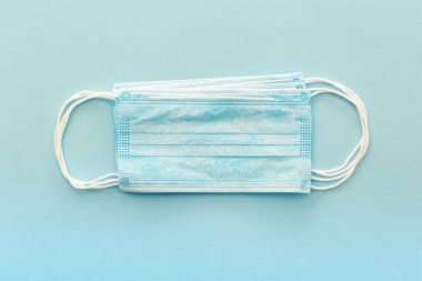 Koronavirüsü önle. Tıbbi maske, tıbbi koruyucu maske mavi arka planda izole edilmiş. Tek kullanımlık yüz maskesi ağız ve burnu kapatır. Sağlık sigortası Coronavirus karantinası, hijyen konsepti.