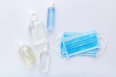 Coronavirus koruması. Tıbbi koruyucu cerrahi maskeler, beyaz masada el dezenfektanı şişesi. Alkol jeli antibakteriyel sabun dezenfektanı, el dezenfeksiyonu. Hijyen koruması Coronavirüs Covid 19.