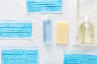Coronavirus koruması. Tıbbi koruyucu cerrahi maskeler, beyaz masada el dezenfektanı şişesi. Alkol jeli antibakteriyel sabun dezenfektanı, el dezenfeksiyonu. Hijyen koruması Coronavirüs Covid 19.