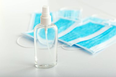 Coronavirus koruması. El dezenfektanı şişesi ve tıbbi koruyucu ameliyat maskeleri beyaz masada. Alkol jeli antibakteriyel sabun dezenfektanı, el dezenfeksiyonu. Hijyen önleme Coronavirüs Covid19.