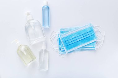 Coronavirus koruması. Tıbbi koruyucu cerrahi maskeler, beyaz masada el dezenfektanı şişesi. Alkol jeli antibakteriyel sabun dezenfektanı, el dezenfeksiyonu. Hijyen koruması Coronavirüs Covid 19.