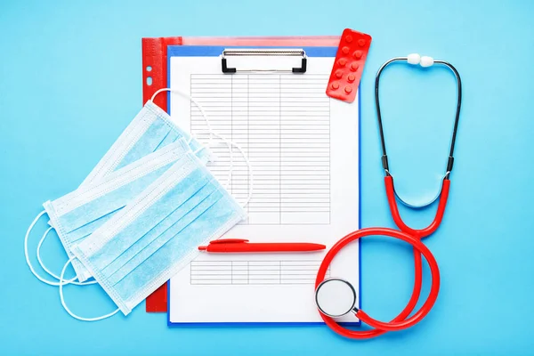 Doctor appointment. Red stethoscope,Medical hygienic masks, tablets, medical documents on doctors workplace in clinic. Concept medicine health care, research, science, virosology, Coronovirus Covid-19