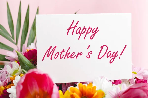 행복 한 어머니들은 분홍색 배경에 꽃다발을 놓고 선물 카드로 문자 메시지를 보냅니다. 엄마한테 온 카드네요. 꽃 배달, 여성을 위한 꽃으로 축하 카드. 분홍색 튤립으로 인사 카드. — 스톡 사진