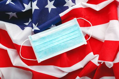 ABD 'de Coronavirus. Amerikan bayrağında koruyucu yüz maskesi. ABD bayrağı ve hijyenik maske koruma viral enfeksiyon koronavirüsü, Covid-19 'un sembolü. İlaç sağlık hizmetleri.