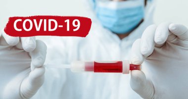 Kırmızı uyarı işaretinde Covid-19 'a mesaj at. Coronavirus kan testi doktorların ellerinde. Koruyucu giysili doktor, biyolojik tehlike, beyaz arka planda maske. Tıp laboratuarı sağlık hizmetleri kavramı.