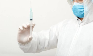 Coronavirus, covid-19. Koruyucu tıbbi giysi giyen doktor ya da bilim adamı, biyolojik tehlike, yüz maskesi laboratuvarda gri arka planda aşı üreten. Tıbbi sağlık hizmetleri pandemik önleme kavramı