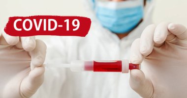 Kırmızı uyarı işaretinde Covid-19 'a mesaj at. Coronavirus kan testi doktorların ellerinde. Beyaz arka planda maskeli bir doktor. Tıp laboratuarı sağlık hizmetleri kavramı. Uzun pankart.