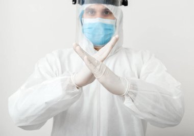 Koruyucu giysi giyen ve yüz maskesi takan doktor jest duruşu gösteriyor. Beyaz arka planda Covid-19 salgını yok, Coronavirus salgını var. Sağlık hizmeti kavramı covid coronavirüs karantinası