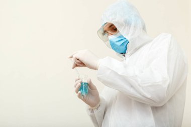 Covid-19 aşısı. Koruyucu tıbbi giysi giyen doktor ya da bilim adamı, biyolojik tehlike, yüz maskesi laboratuvarda koronavirüs aşısı üretiyor. Tıbbi sağlık hizmetleri pandemik önleme kavramı.