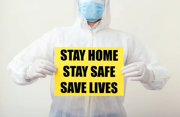 Stay Home Stay Safe Save Lives text on yellow warning sign in doctors hands. Coronavirus, Covid-19 self quarantine isolation. Medical, healthcare social distancing concept