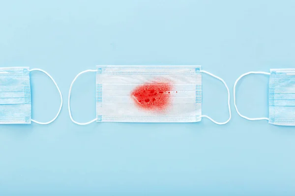 Hemoptisis, koronavirüs, mavi arka planda kan olan koruyucu cerrahi maskeler. Zatürree, akut solunum enfeksiyonları, tüberküloz, akciğer kanseri, hemofili, salgın. 2020 Çin Coronavirüsü