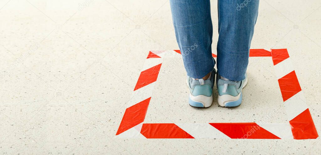 Red striped line sign for keeping social distance. Woman standing behind a warning line during covid 19 coronavirus quarantine. Safe shopping, Social distancing concept. Web banner with copy space.