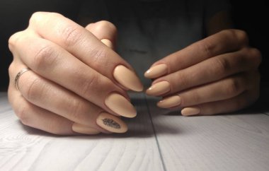 Siyah geometrik kalem tasarımlı şeftali jeli cilası. Uzun yuvarlak çivilerin üzerindeki kamuflaj pastel kaplamasının geometrik detaylarını içeren siyah yaprak tasarımı.