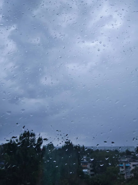 城里在下雨 从窗户往外看 傍晚时分 窗外下起雨来 玻璃杯上的大滴水 — 图库照片