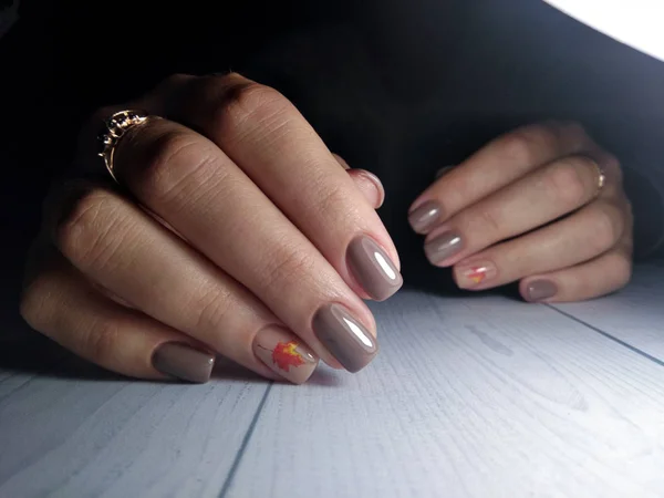 棕色秋胶清漆 枫叶设计的妇女指甲的整洁修指甲 橘红色枫叶图案 — 图库照片