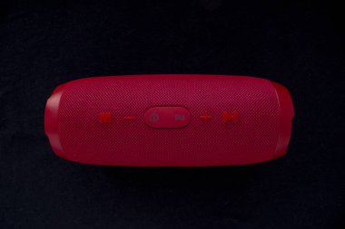 Kablosuz müzik hoparlörü. Siyah arkaplanda kırmızı bluetooth hoparlörü. Denetim ve ses düğmeleri.