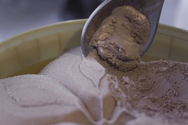 Bir kova çikolatalı dondurma ve kaşık. Kaşık, çikolatanın tadındaki dondurmayı aldı. Güzel dondurma deseni.