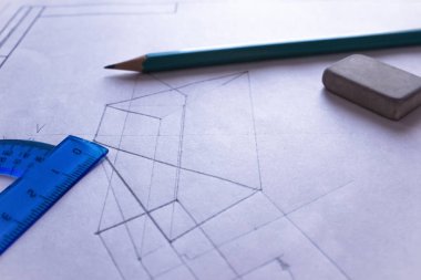 Bir açıölçer, kalem ve silgi beyaz kağıda çizilmiş bir şekilde uzanır. Kırtasiyeli büyük bir sayfaya çizilmiş diyagram