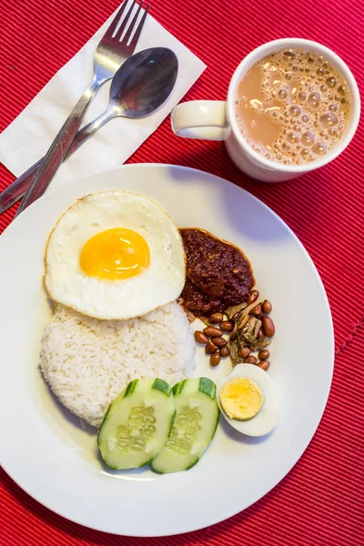 Malaiisches Essen - nasi lemak und schäumendes teh tarik auf rotem Backblech — Stockfoto