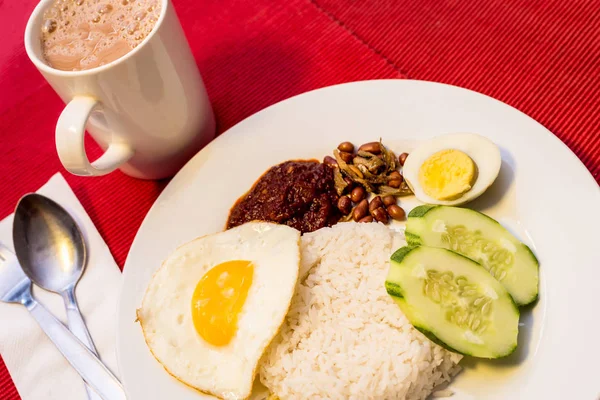 Malaiisches Essen - nasi lemak und schäumendes teh tarik auf rotem Backblech — Stockfoto