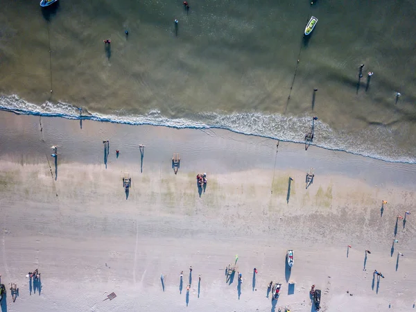 Aerial Tilt Shift View - People Walking at the beach. High angle