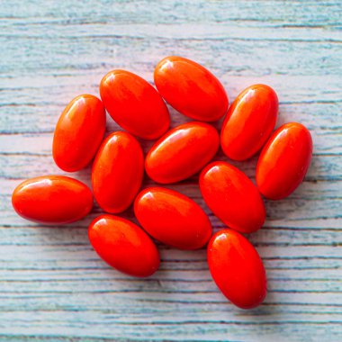 Tahta arka planda kırmızı renkli vitamin hapları. Yumuşak odaklı. Evet.