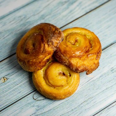 Koyu mavi ahşap sırtlı ev yapımı puf böreği.