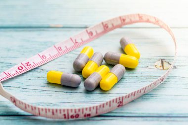 Tahta arka planda mezuralı diyet hapları. Diyet içeriği