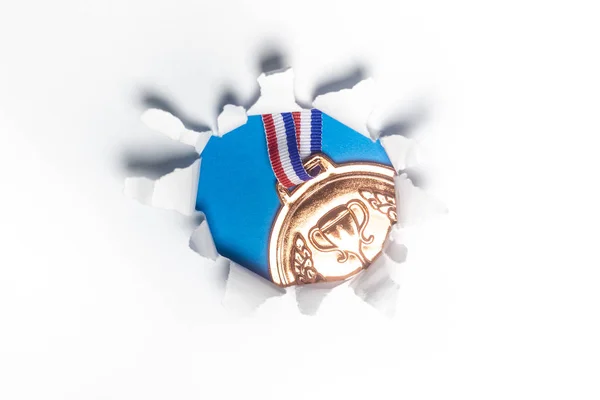 Бронзовая Медаль Через Рваную Бумажную Дыру Спортивная Концепция — стоковое фото