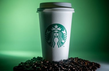 Kuala Lumpur, 2020 dolaylarında Starbucks kahve fincanı ve kahve çekirdeği yeşil renkli arka planda izole edilmiş. Starbucks Corporation bir Amerikan kahve şirketi ve kahve zinciri..