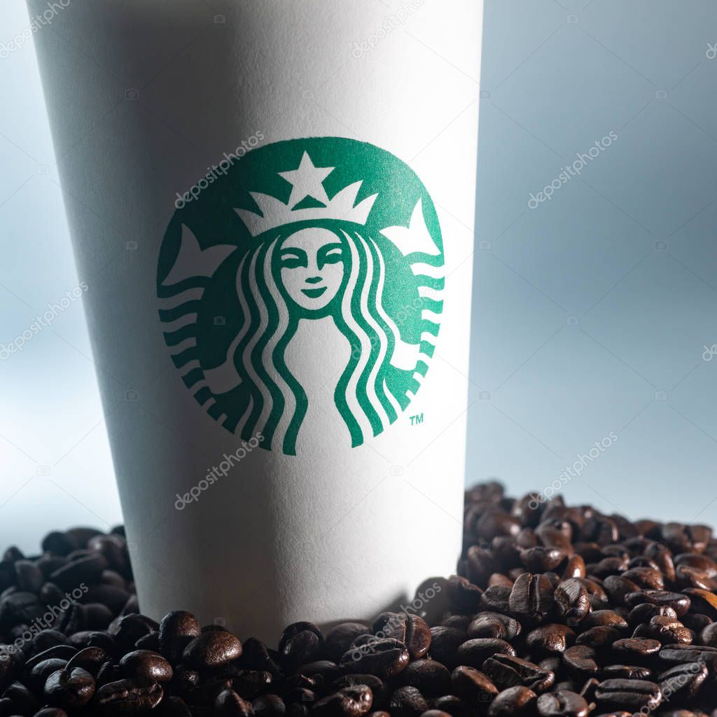 Kuala Lumpur, Circa 2020 - Starbucks Coffee cup and Whole Coffee Beans isolated on dark background.  Starbucks Corporation is an American coffee company and coffeehouse chain.