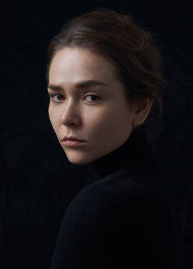 Çiller Studio siyah arka plan üzerine siyah bir balıkçı yaka içinde güzel bir genç kızla dramatik portresi