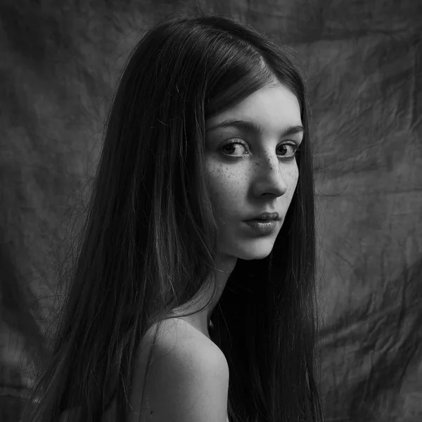 Δραματική ασπρόμαυρη προσωπογραφία ενός όμορφου μοναχικού κοριτσιού με φακίδες απομονωμένες σε σκοτεινό φόντο σε στούντιο γυρισμένο — Φωτογραφία Αρχείου