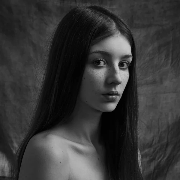 Dramatyczny czarno-biały portret pięknej samotnej dziewczyny z piegami odizolowanej na ciemnym tle w studio shot — Zdjęcie stockowe
