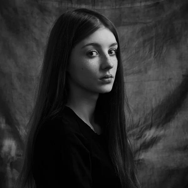 Film stüdyosunun karanlık arka planında yalnız ve güzel bir kızın dramatik siyah beyaz portresi. — Stok fotoğraf