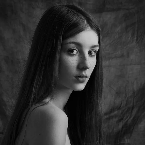 Retrato dramático en blanco y negro de una hermosa chica solitaria con pecas aisladas sobre un fondo oscuro en un plano de estudio — Foto de Stock