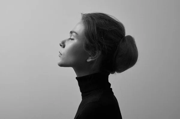 Dramatisches Schwarz-Weiß-Porträt eines jungen schönen Mädchens mit Sommersprossen in einem schwarzen Rollkragen auf weißem Hintergrund im Studio — Stockfoto