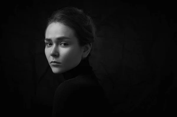 Dramático preto e branco retrato de jovem menina bonita com sardas em uma gola preta no fundo preto no estúdio — Fotografia de Stock