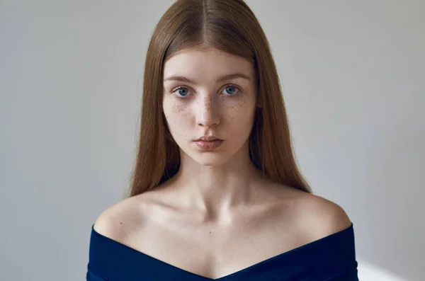 Güzellik Tema: çiller yüzünü ve Studio beyaz zemin üzerinde mavi bir elbise ile güzel bir genç kız portresi — Stok fotoğraf